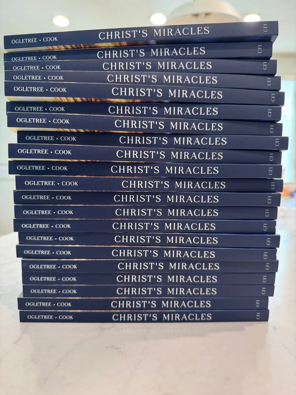 Stack of Christ&rsquo;s Miracles books, navy spines
